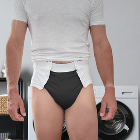 A man wearing a white incontinence diaper with snaps at the front for easy removal.